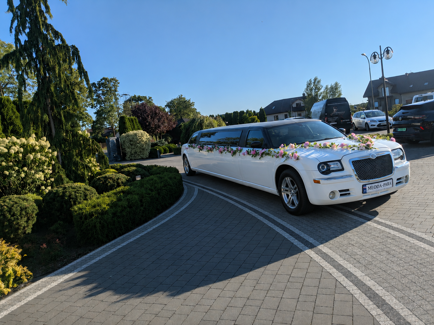 Limuzyna Chrysler z tablicą MŁODA-PARA przed rezydencją weselną
