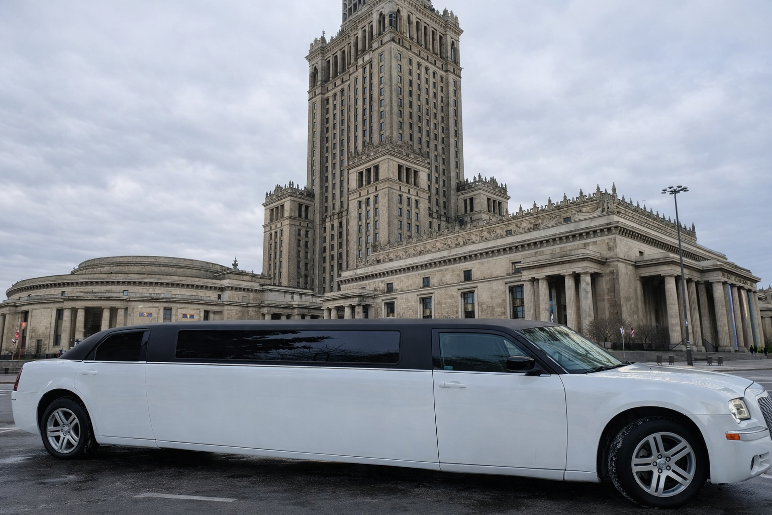 Limuzyna Chrysler z profilu na tle Pałacu Kultury i Nauki