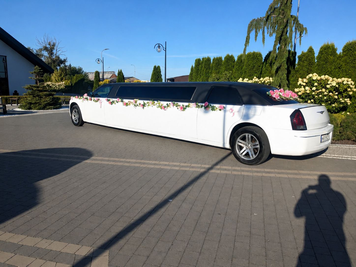 Tył udekorowanej limuzyny Chrysler przed salą weselną